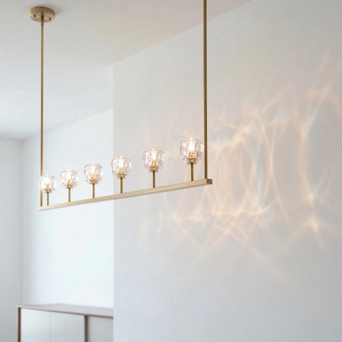 Soft light patterns reflected on a wall from a linear crystal chandelier.