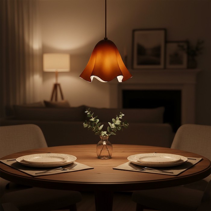 Warm ambient lighting from a floral glass chandelier over a dinner party setup.