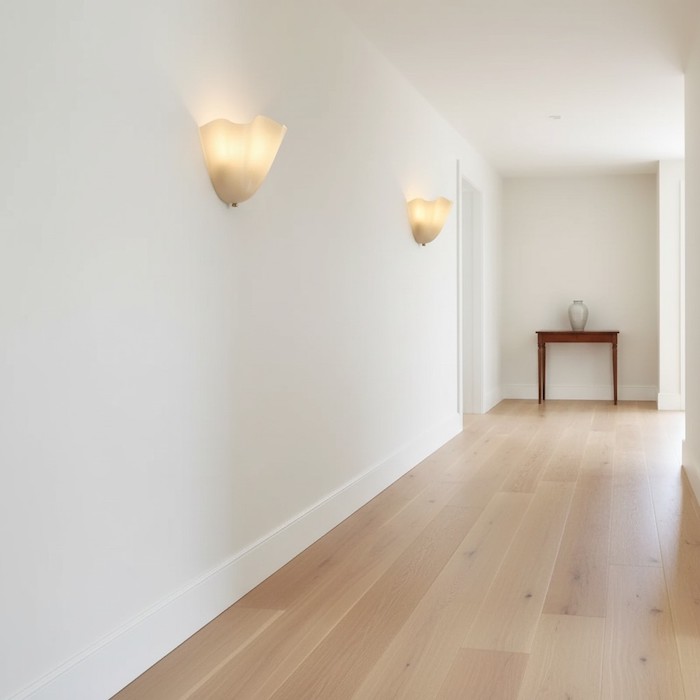 Layered hallway lighting using floral Art Deco wall sconces for a luxury feel.