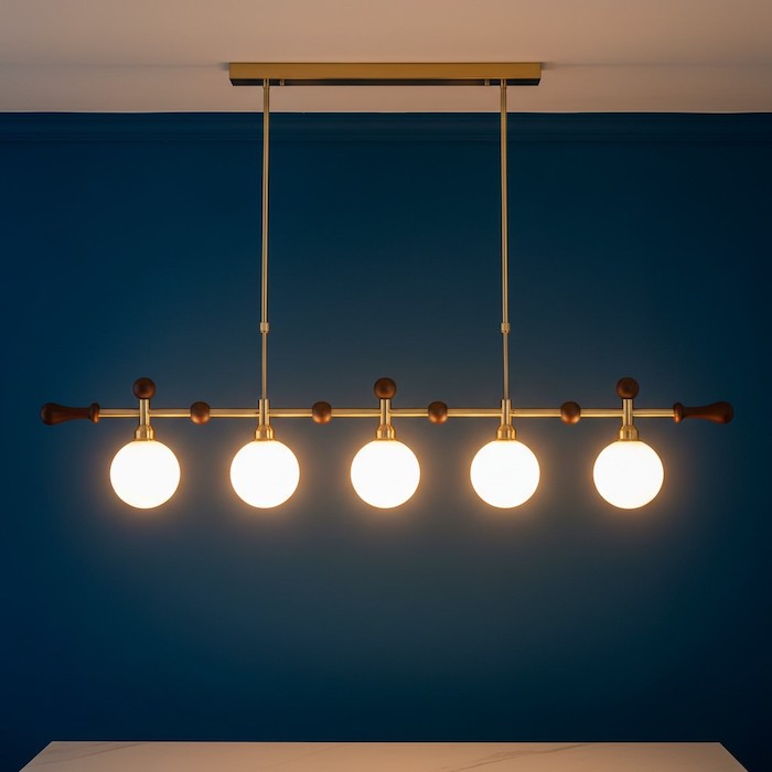 Close-up of a linear chandelier glowing during the evening.
