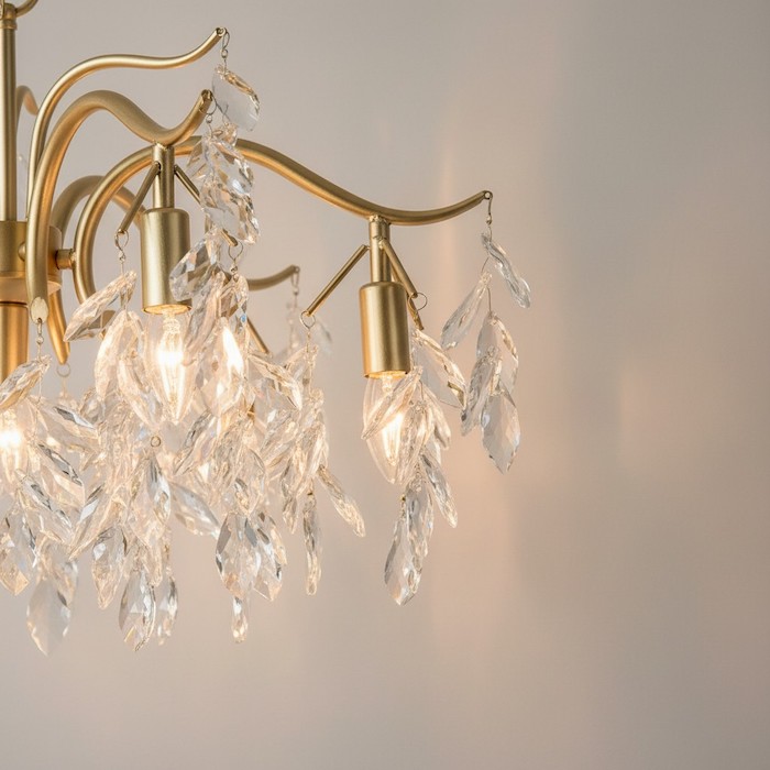 Close-up of gold metal details on a luxury crystal chandelier.