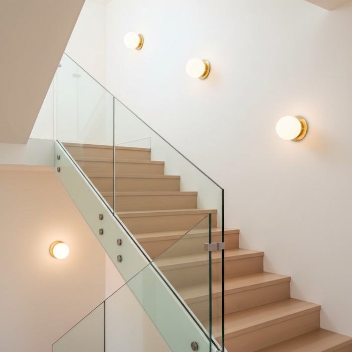 Wall-mounted globe lights illuminating a modern staircase.