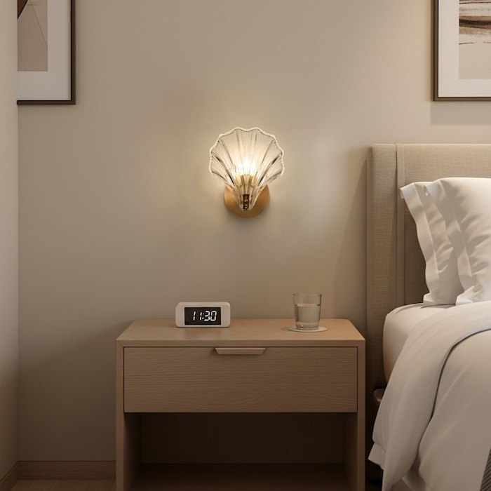 Wall-mounted sconce saving space on a bedside table.