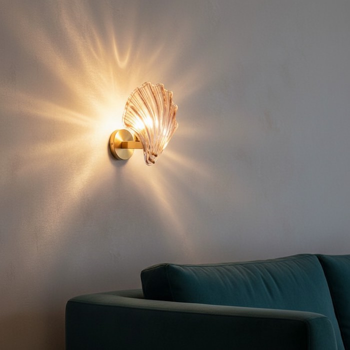 Soft diffused glow of a shell glass wall sconce on silk wallpaper.