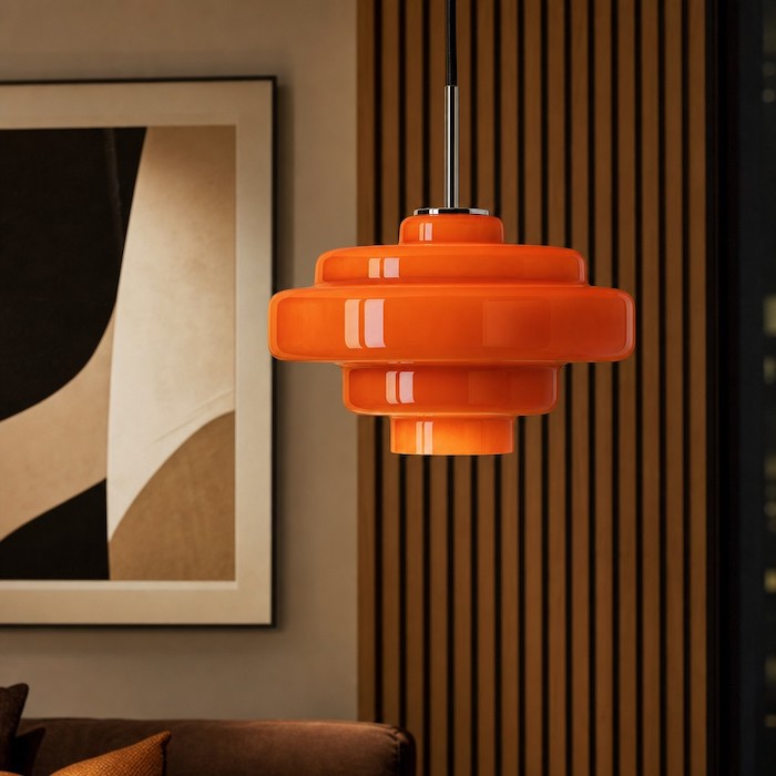 Glass pendant light reflecting modern room textures and materials.