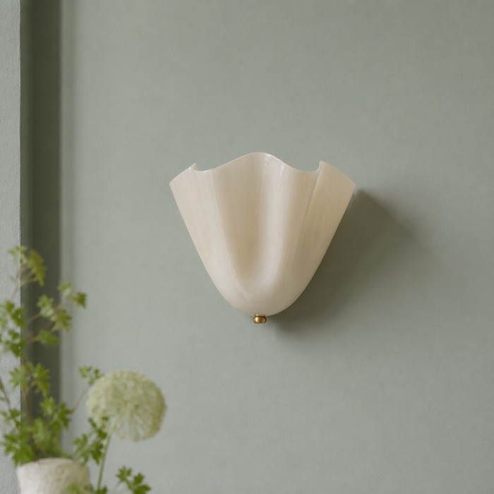 Elia seashell sconce against a muted sage green Nordic wall.