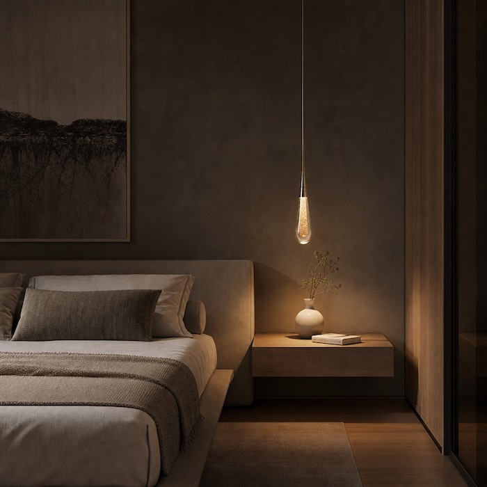 Single head teardrop gold pendant lamp utilized as an elegant bedside reading light.
