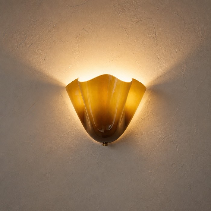 Close-up of seashell wall sconce casting floral shadows.