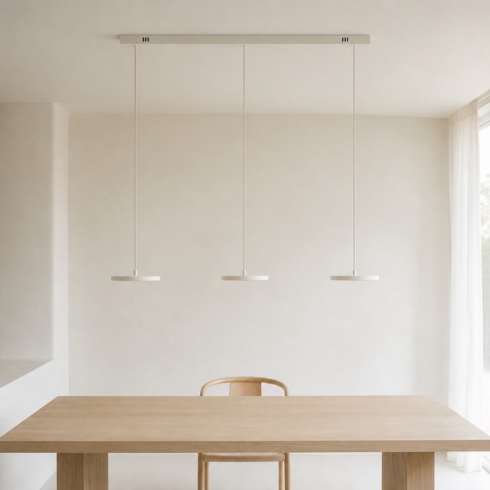 Beige-weiße, lineare Pendelleuchte, die sich nahtlos in eine neutrale Decke einfügt.