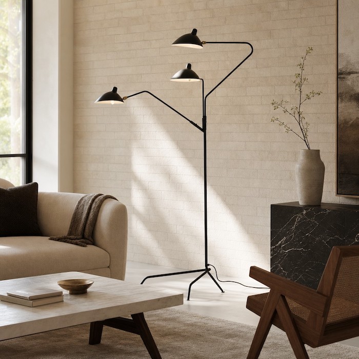 Sculptural matte black iron floor lamp serving as a fine-art installation in a modern home corner.