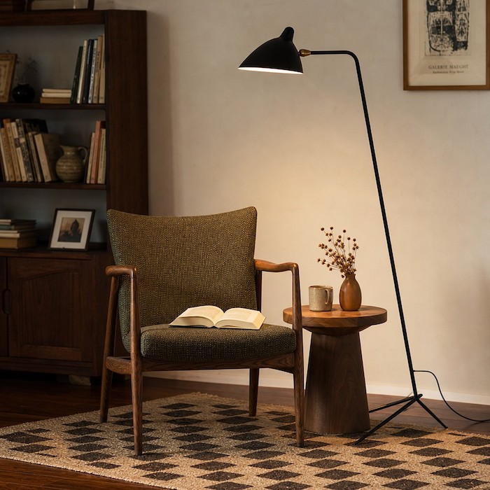Skulpturale Stehlampe aus mattschwarzem Metall mit verstellbarem Schirm in einer gemütlichen Leseecke im Mid-Century-Stil.