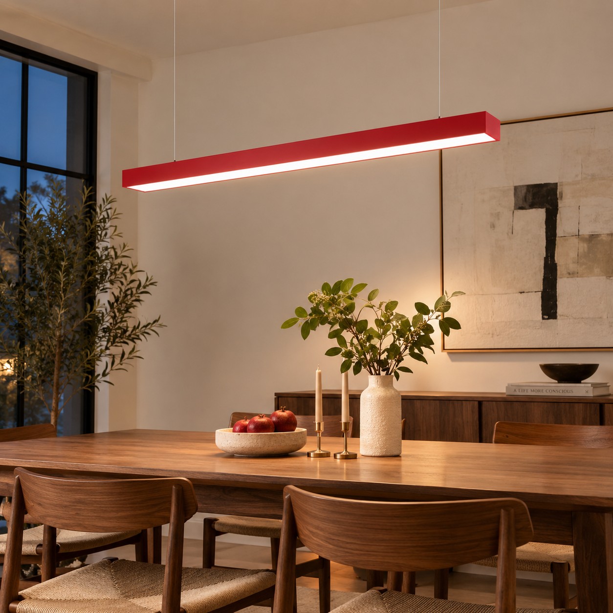 Red rectangular pendant organizing a lived in dining table at night