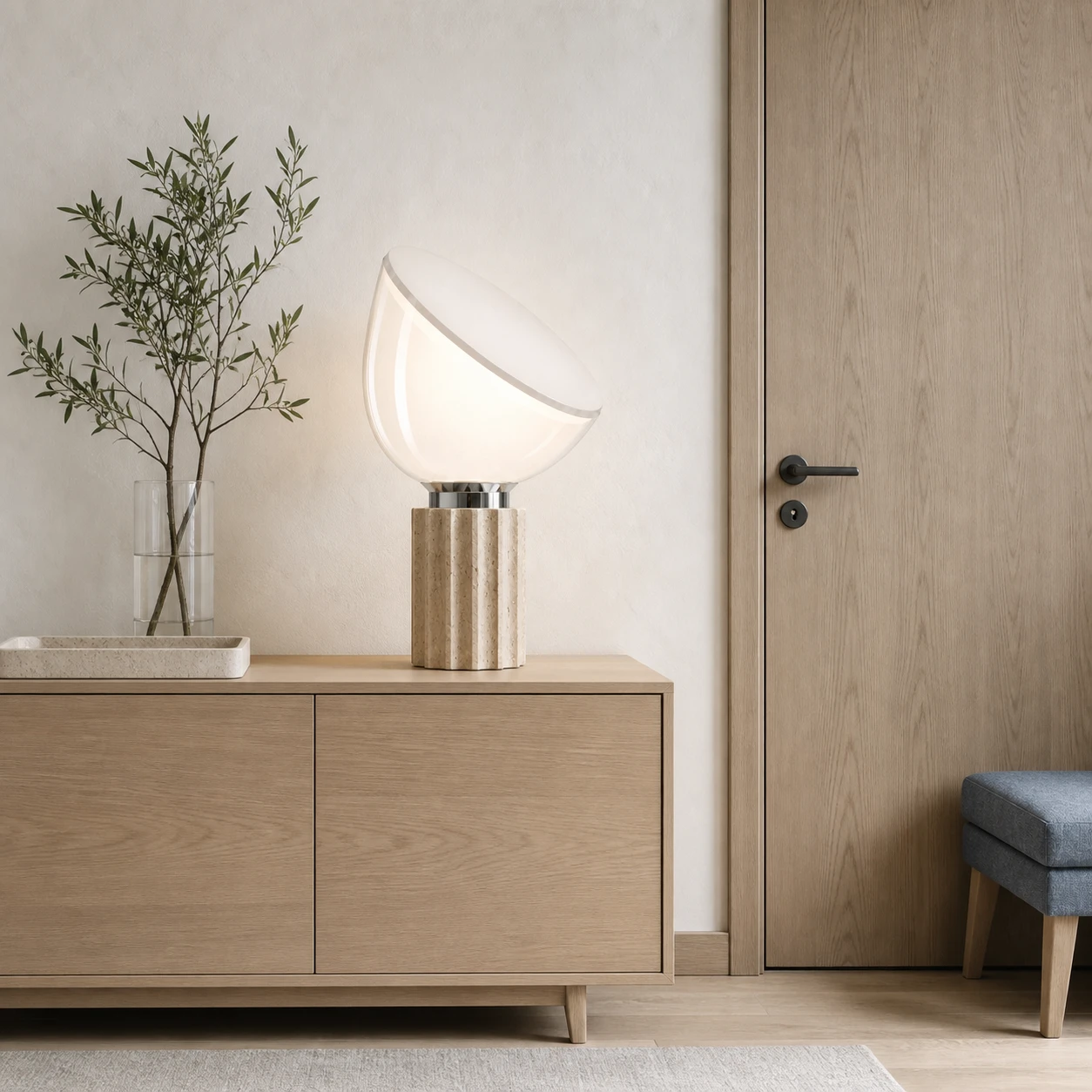 Taci lamp on a sideboard beside a closed Nordic entrance door