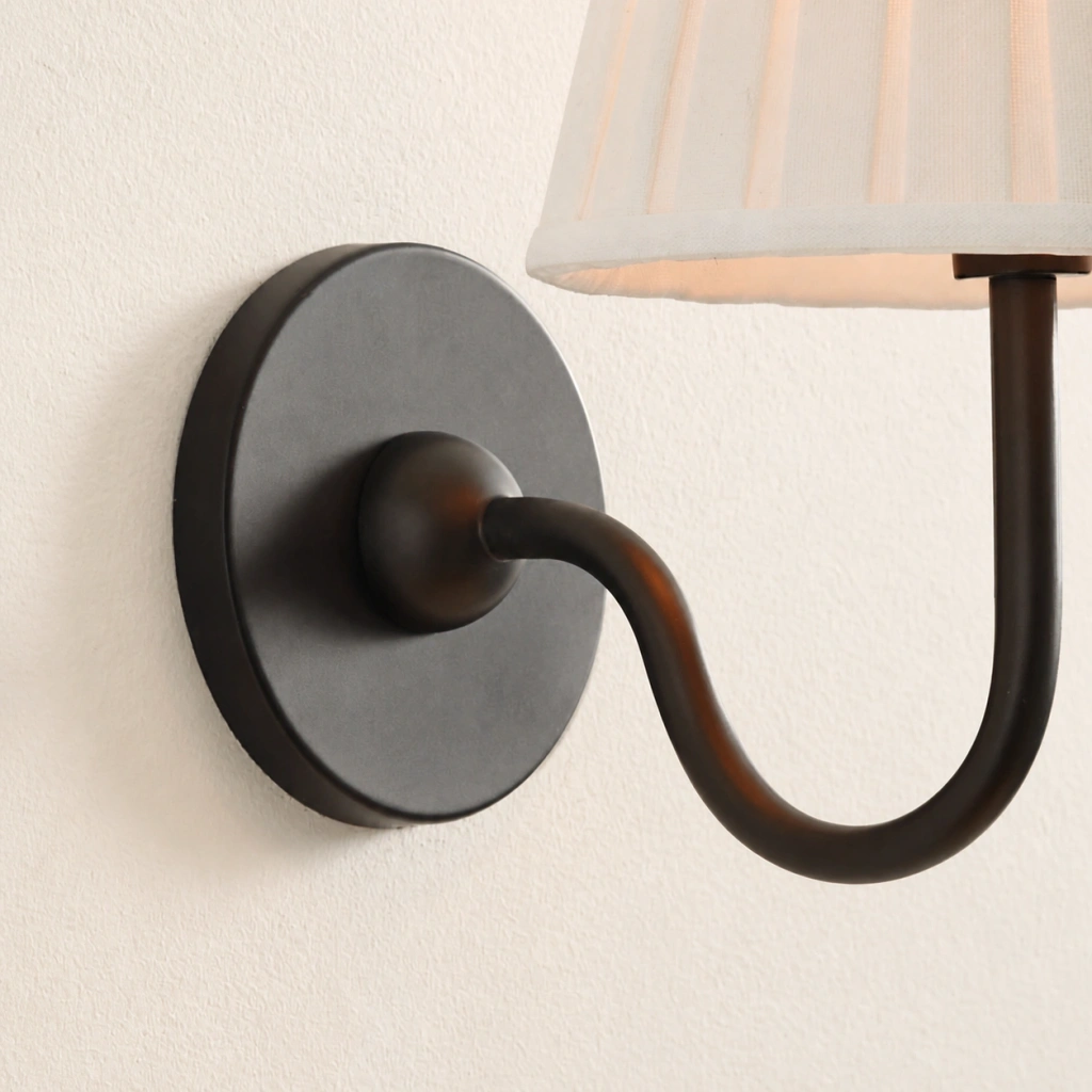 Close detail of the round plate and curved bronze arm