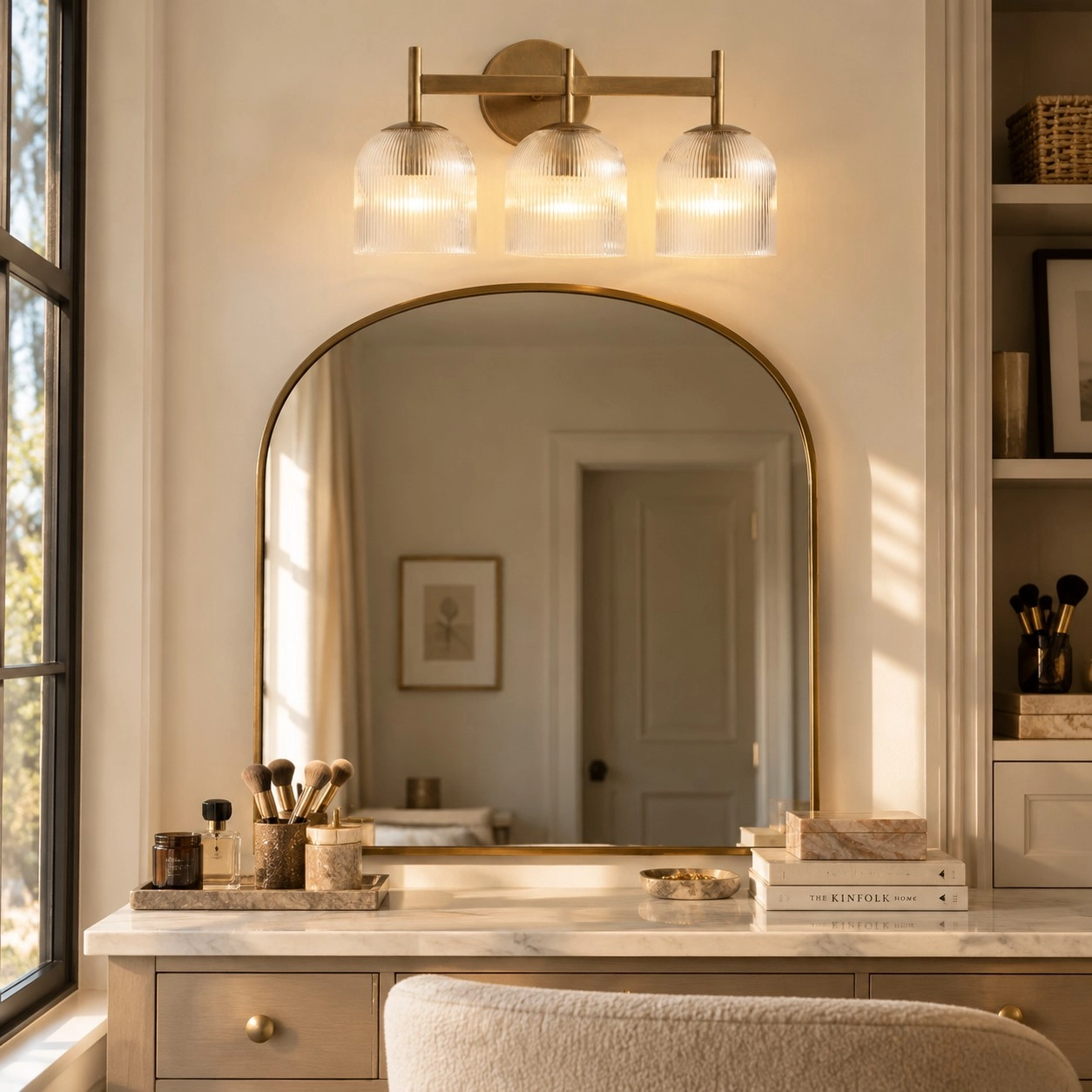 Three-head wall light above a warm vanity